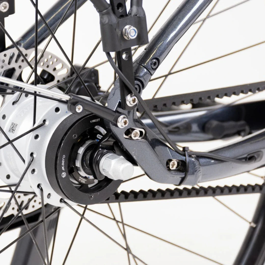 The product pictured is an Electric Bike, model Econo Mare City. The image shows a part of the rear wheel, where the electric motor unit integrated into the wheel hub is visible. Parts of the frame and brakes are also visible, indicating a robust design suitable for city riding.