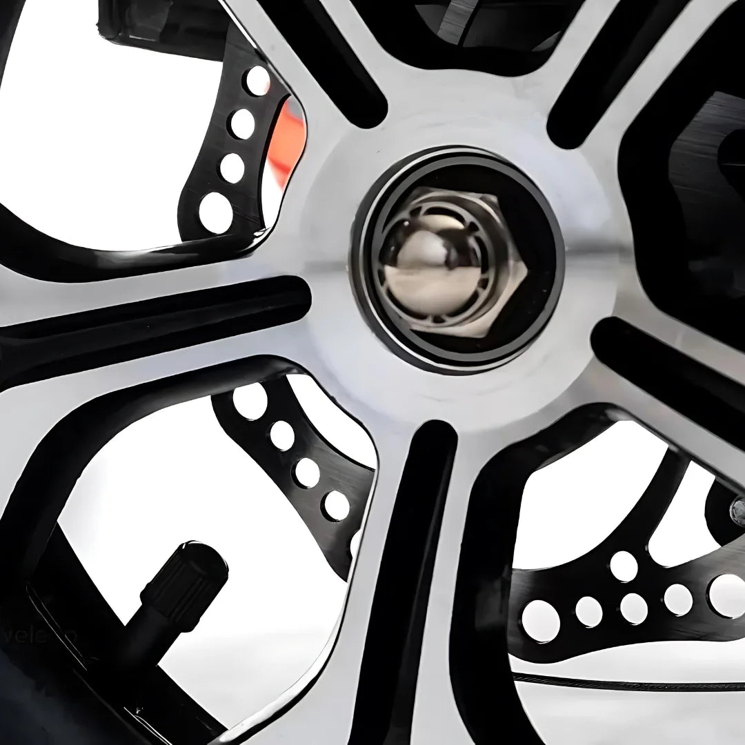 The product is an Electric Mobility Scooter, model Veleco ZT16. The image displays a part of the wheel, which includes a multi-spoke aluminum rim and a visible lug nut. The wheel also features cutouts, which can help reduce weight and improve aerodynamics. The overall appearance indicates a modern and robust design, suitable for mobility.