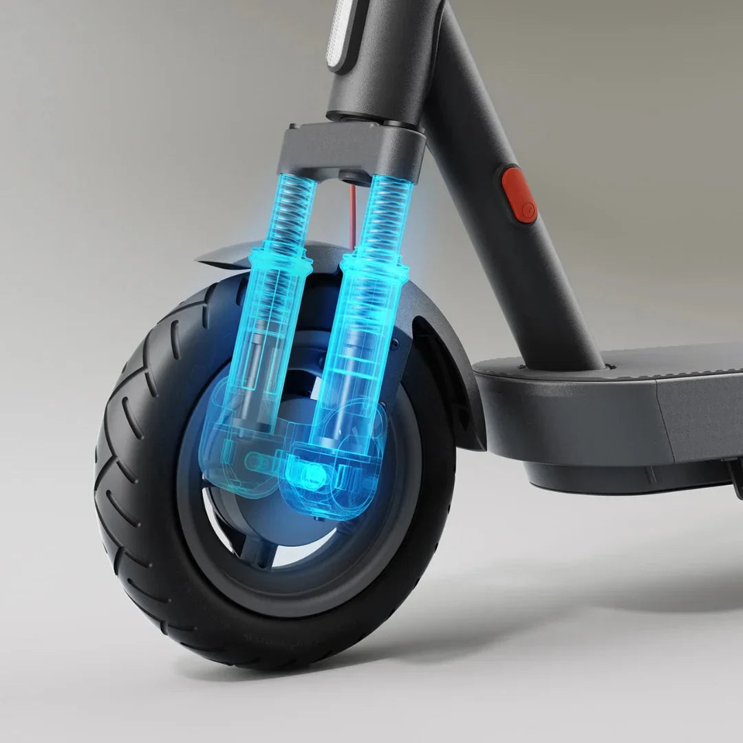 The image shows an Electric Scooter from the brand Xiaomi, model 5 Max GL. The front wheel fork is visible, featuring visible shock absorbers, which suggests improved riding comfort. The wheel has a wide tire, contributing to stability and safety during the ride.