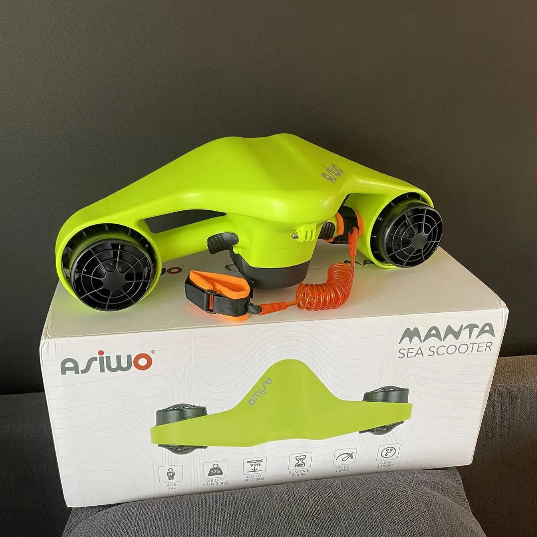 The product in the image is an electric underwater scooter, model Manta, by Asiwo. The image shows a bright green device with two propellers, designed for fun underwater swimming. The scooter is placed on a box containing additional product information.