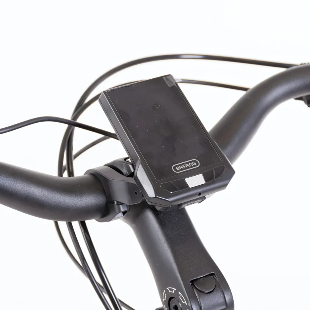 The product pictured is the Electric bike Econo Mare City EEC4LK. The image shows a part of the handlebars, featuring a Bafang display that shows ride information. Cables connected to the display and ergonomically designed handlebars are also visible.