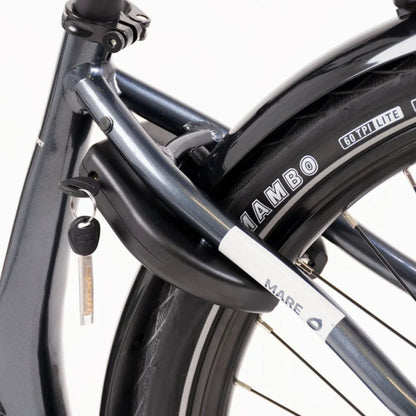 The product is an electric bike, brand Mare, model Econo Mare City. The image shows the bike's structure, which includes a dark blue frame and a lock attached to the frame. A tire labeled "Mambo" is also visible, indicating quality tires. The bike has a modern design, making it suitable for city riding.