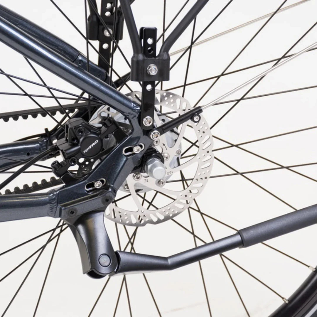 The product is an Electric bike, model Econo Mare City. The image shows the rear part of the bike, where the brakes and part of the frame are visible. Features include disc brakes, ensuring efficient stopping, and part of the mechanism for smooth operation. The frame color is dark, giving the bike a modern look.