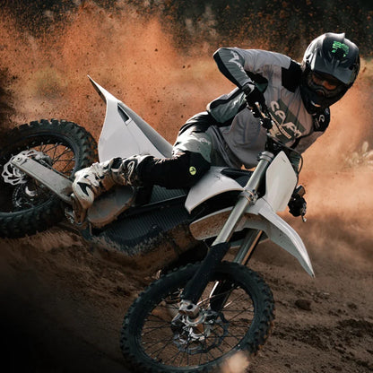The rider of a Stark Varg electric motocross bike kicks up dust while sharply cornering.
