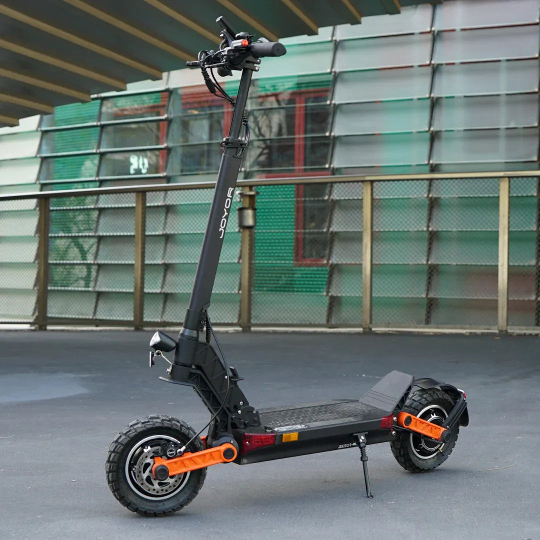 The product pictured is an Electric Scooter, model Joyor S10-SZ. The image shows a scooter with a black frame and orange accents, featuring a wide deck/footboard and robust tires, indicating its suitability for various terrains. The handlebars are equipped with various controls, allowing for easy riding.