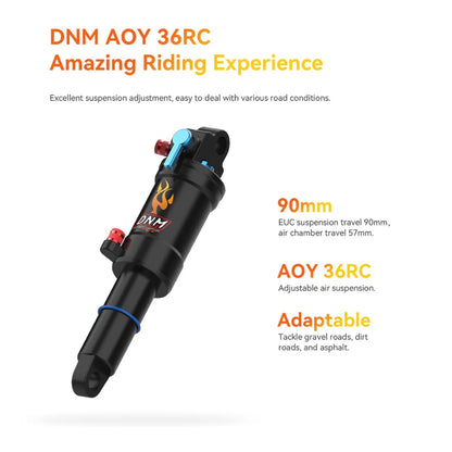 The image displays the DNM AOY 36RC shock absorber, designed for electric unicycles (EUCs). This shock absorber features adjustable air suspension with 90 mm of travel, ensuring a comfortable ride across various terrains such as gravel roads, dirt paths, and asphalt. Details of the shock absorber, including adjustments and color markings, are visible in the image.