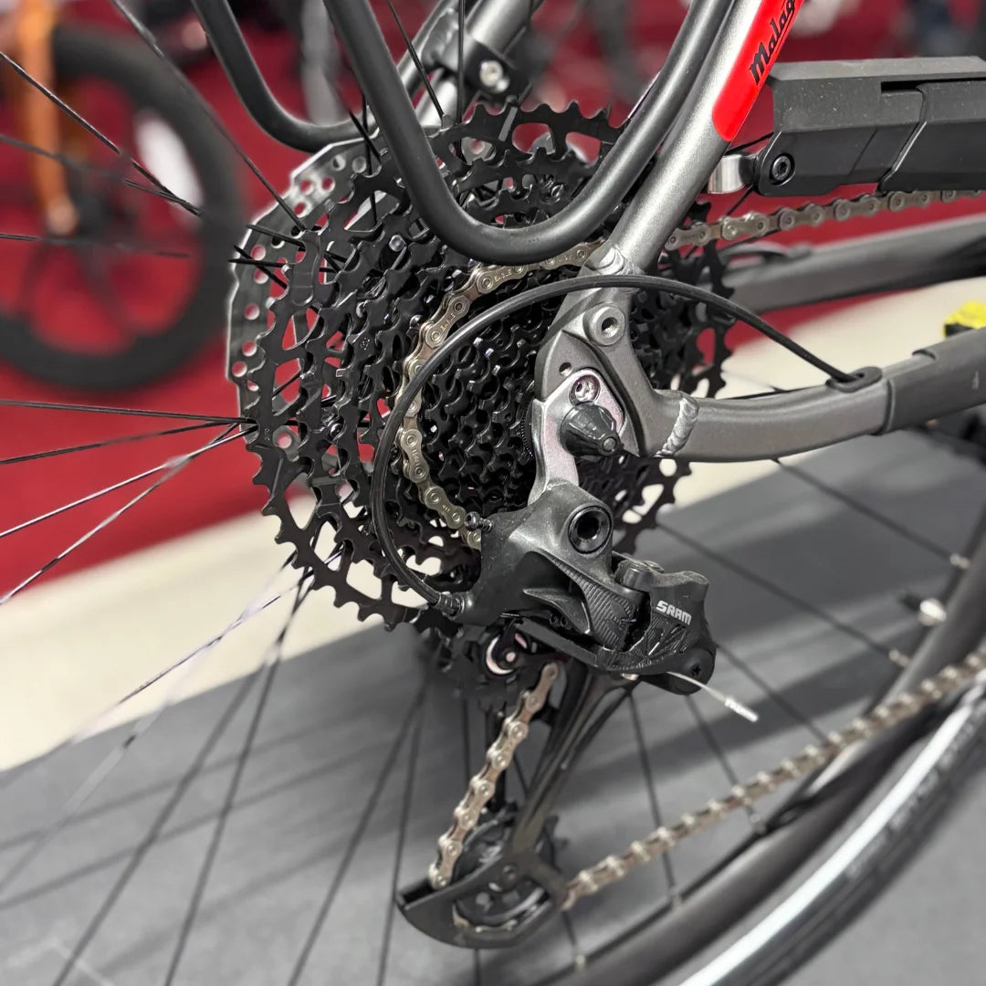 The product is an electric bike from the brand Malaguti, model Bolonina. The image shows the rear part of the bike, where the derailleur and sprocket are visible. The derailleur is from the SRAM brand, indicating quality equipment. The bike is designed for efficient shifting and riding on various terrains.