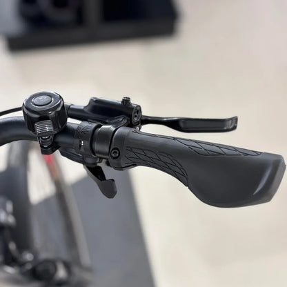 The product is an Electric bike of the brand Malaguti, model Bolonina. The image shows a part of the handlebars, which includes the brake lever, grip, and bell. The grips are designed for comfortable handling, allowing for better control while riding.