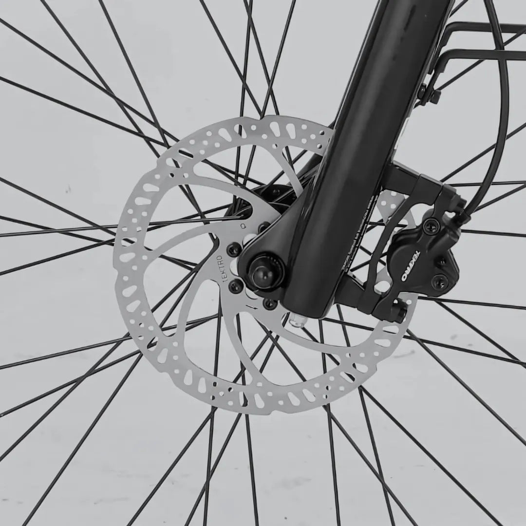 The product is an Electric bike, model MS Energy C300. The image shows a part of the front wheel with a disc brake system. The brake, including the caliper and rotor, is visible, indicating modern braking technology that ensures efficient and safe stopping. The bike also features a black frame and other components.