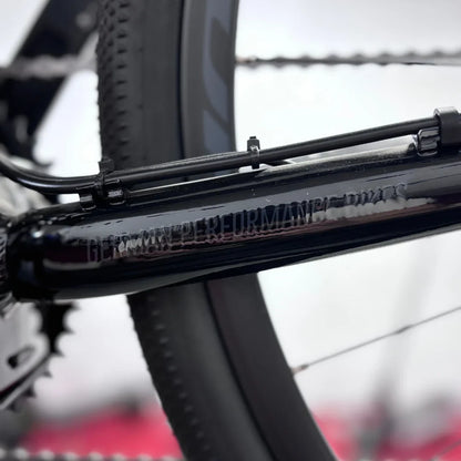 The product is an Electric bike, Raymon brand, model GravelRay E 7.0. The image shows a part of the bike frame, which is black, with visible details such as cables and gears. The equipment indicates high-quality manufacturing, typical of this brand. The bike is designed for riding on gravel surfaces and offers good performance.