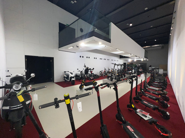 Display of electric scooters in a showroom setting with a modern interior.