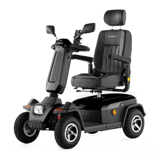 Izdelek na sliki je električni skuter, model Veleco Sharpy. Na sliki je prikazan skuter z udobnim sedežem, naslonjalom za glavo in ročaji. Ima široke pnevmatike za boljšo stabilnost in manevriranje, kar je primerno za uporabo na različnih površinah. Zasnova je moderna in funkcionalna, kar omogoča enostavno vožnjo.