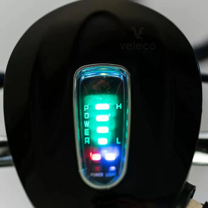 The product is an Electric Mobility Scooter, model Veleco ZT16. The image shows a part of the control panel, where LED indicators for power and battery level are visible. The indicators are illuminated in different colors, allowing the user to easily monitor the scooter's status. The Veleco brand is known for its electric mobility solutions.
